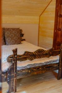 Cama de madera en habitación con paredes de madera en Садиба над потоком, en Lumshory