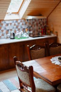 cocina con mesa de madera con sillas y fregadero en Садиба над потоком, en Lumshory