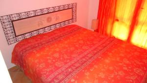 a red bed in a room with a window at PORTO POLLO WIND & LOVE in Barrabisa