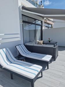 Duas espreguiçadeiras e uma cama numa varanda. em Luxury apartment in Puerto Rico -Gran Canaria em Mogán