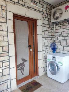 a washing machine in front of a house with a door at Alexis's House in Pylos