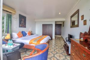 pokój hotelowy z łóżkiem, stołem i krzesłami w obiekcie Ocean Suite Goa w mieście Dona Paula