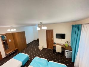 una camera d'albergo con 2 letti e una scrivania di Hostel Paltinis a Hunedoara