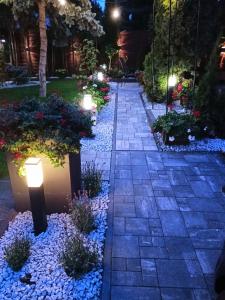 Una pasarela con luces en un jardín por la noche en Pokoje hotelowe Nad Zalewem, en Siedlce