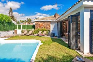 a backyard with a swimming pool and a house at Chalet Isabel in Maspalomas