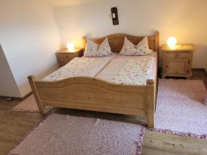 a bedroom with a wooden bed with two night stands at Ertlhof Rottau in Rottau