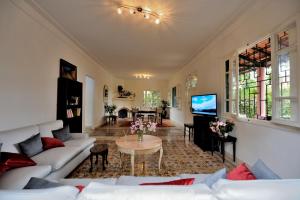 a living room with white couches and a table at Charmante Maison 2ch et Bungalow 2ch au Coeur de l'Oasis in Casablanca