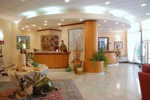 a lobby with a waiting area with potted plants at Hotel La Fenice in Formigine