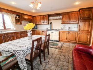 uma cozinha com uma mesa com um vaso de flores em Derriens Farmhouse em Enniskillen