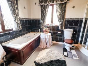 a bathroom with a tub and a toilet at Derriens Farmhouse in Enniskillen