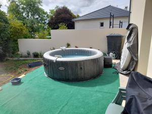 a backyard with a hot tub on a green lawn at CHEZ VIVIANE in Celles-sur-Belle