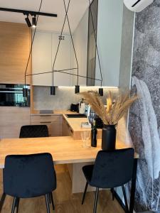 a kitchen with a wooden table and two chairs at Family & Business Elegant Apartments ul Lotnicza Centrum Galeria Korona - 1 Bedroom, Terrace, Air Conditioning, Garage - NEW! in Kielce