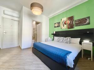 1 dormitorio con 1 cama grande y paredes verdes en MilanHolidays, en Milán