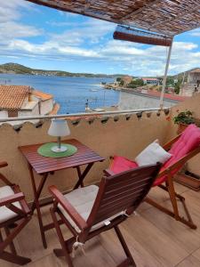 Un patio con sillas y una mesa y vista al agua. en Apartment Lili, en Šibenik