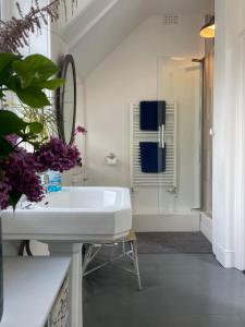 een witte badkamer met een wastafel en een douche bij Lauderdale lodge barnstaple in Barnstaple