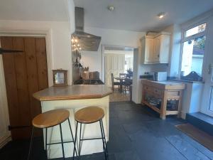 a kitchen with two bar stools and a counter top at Lauderdale lodge barnstaple in Barnstaple