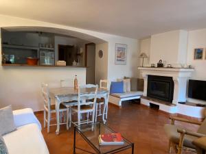 ラマチュエルにあるFERME DU MOULIN ROUX- 2 spacieux appartements- 2cbres chacun- Authentique ferme provençale- RAMATUELLEのリビングルーム(テーブル、暖炉付)