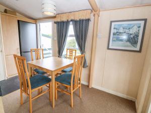 uma sala de jantar com uma mesa e cadeiras e uma janela em Plas Tirion Caravan em Holyhead