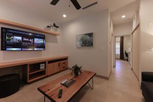 a living room with a table and a tv on the wall at The Bungalows on Shary in McAllen