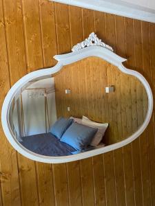 Cama en habitación de madera con espejo en Casa da Pena, en Mondim de Basto