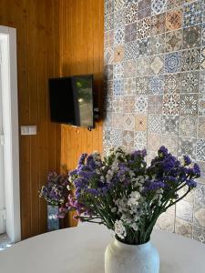 a vase filled with purple and white flowers on a table at Casa da Pena in Mondim de Basto