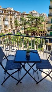 een blauwe tafel en 2 stoelen op een balkon bij Dudi Apartment in Palermo