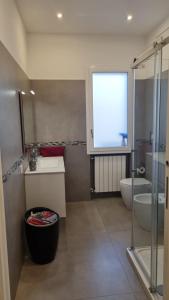 een badkamer met een wastafel, een toilet en een raam bij Dudi Apartment in Palermo
