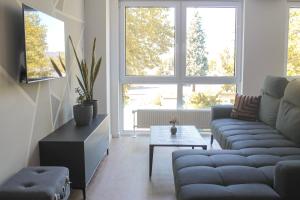 a living room with a couch and a table at New York Apartment - für Freunde & Familien, stadtnah, Parkplatz, E-Ladestation, Gitterbox für Fahrräder, Fitnessstudio, digitale Gästemappe mit Restaurant- und Unternehmenstipps in Koblenz