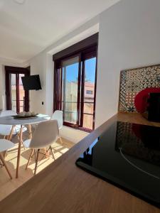 ein Wohnzimmer mit einem Tisch, einem Tisch und Stühlen in der Unterkunft Duplex Los Serrano in Salamanca