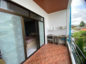 una camera da letto e un balcone con tavolo. di Da Puccio Rawai Guesthouse a Rawai Beach