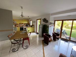 a kitchen and living room with a table and chairs at Maison de vacances l’Émeraude in Saint-Coulomb