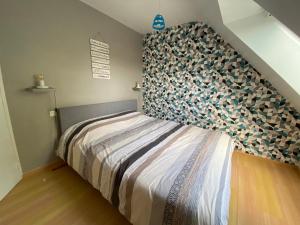 a bedroom with a bed with a large headboard at Maison de vacances l’Émeraude in Saint-Coulomb