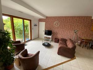 a living room with a couch and chairs and a tv at Maison de vacances l’Émeraude in Saint-Coulomb