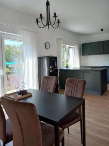 a kitchen with a dining room table and chairs at HOME OF VACATION - Ferienhaus bei Celle nähe Hannover - FREE WIFI & Netflix in Adelheidsdorf