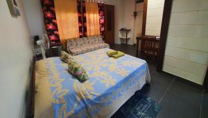 1 dormitorio con 1 cama con manta azul y amarilla en Residence Vainau Moorea en Haapiti