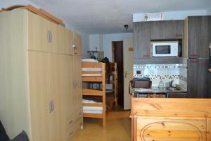 a small room with a kitchen and a bunk bed at Appartement Le Vernon in Chamrousse