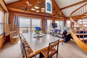 a dining room with a table and chairs and a staircase at Sandfiddler 175 in Avon