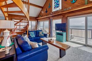 a living room with a blue couch and a tv at Sandfiddler 175 in Avon