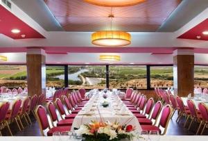 a banquet hall with a long table and pink chairs at Hospedium Hotel Juan II in Toro