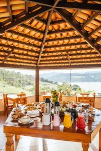 uma mesa de madeira com pratos de comida em Pousada Enseada da Ilha em Capitólio