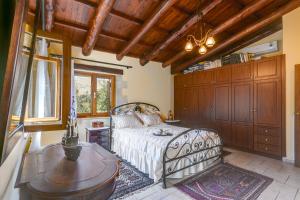 Un dormitorio con una cama y una mesa. en Ifigenia Lux MAISONETTE in oldtown and Villas in theriso vilage 14 km outside of chania, en La Canea