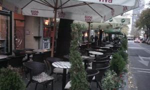 a row of tables and chairs outside of a restaurant at Slavija Square Apartment Cvetni Trg in Belgrade