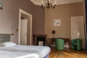 a bedroom with a bed and a desk and a chair at Domaine Du Chateau De La Neuville in Tihange