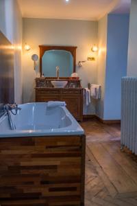 a bathroom with a large tub and a sink at Domaine Du Chateau De La Neuville in Tihange