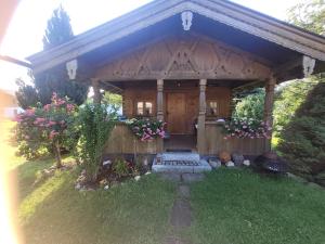 a wooden gazebo with flowers in front of it at Ertlhof Rottau in Rottau