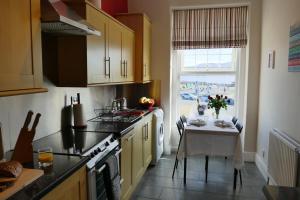 a kitchen with a table and a kitchen with a window at ShellSeekers Holiday Apartment, Llandudno in Llandudno