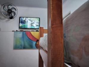 une chambre avec un lit superposé avec une télévision et un ventilateur dans l'établissement Kitconforto, à Guarujá