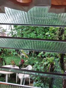 Elle offre une vue sur une terrasse avec une table et des plantes. dans l'établissement Kitconforto, à Guarujá 9 autres photos
