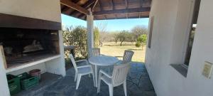 una mesa y sillas en un patio con chimenea en Casa Condal en Villa General Belgrano