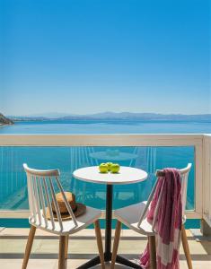 einen Tisch und Stühle auf einem Balkon mit Blick auf das Wasser in der Unterkunft Galini Mare in Agia Galini